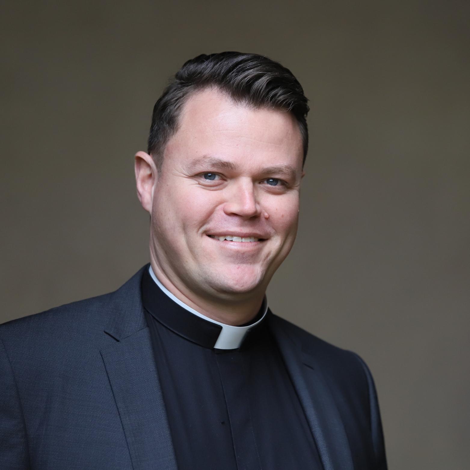 ein junger Priester vor einem grauen Hintergrund (c) Propeller/ Bistum Trier ein junger Priester vor einem grauen Hintergrund